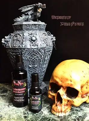 Entdecke die düstere Ästhetik von Dark Phönix in Xanten: Ein stimmungsvolles Arrangement aus einer kunstvollen Drachen-Urne, einem Totenkopf und dem exklusiven 'Leichenwasser' Parfüm.