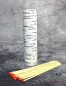 Preview: Hexenshop Dark Phönix Ein 20 cm langes Streichholz entzündet eine tiefe Ritualglaskerze, dekorative Baumrinden-Verpackung im Hintergrund.